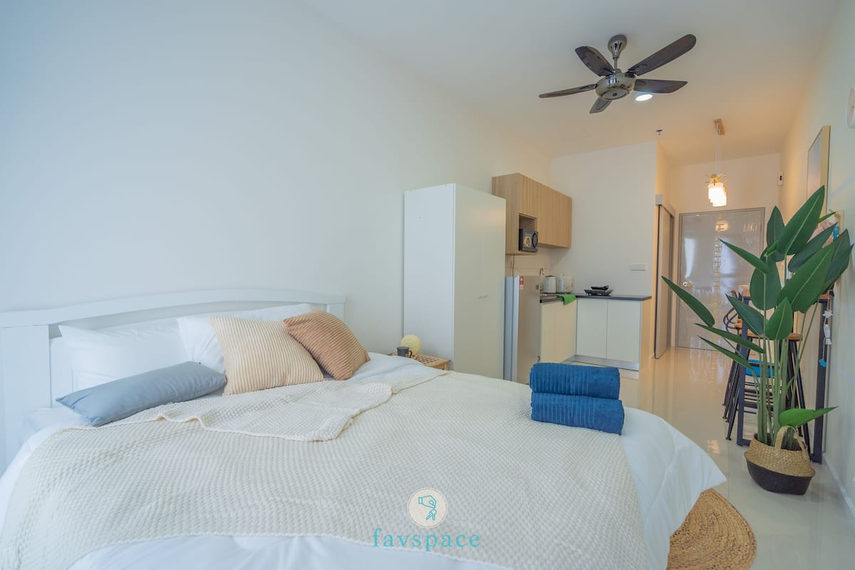 A modern bedroom with a bed, bedside table, and a ceiling fan.