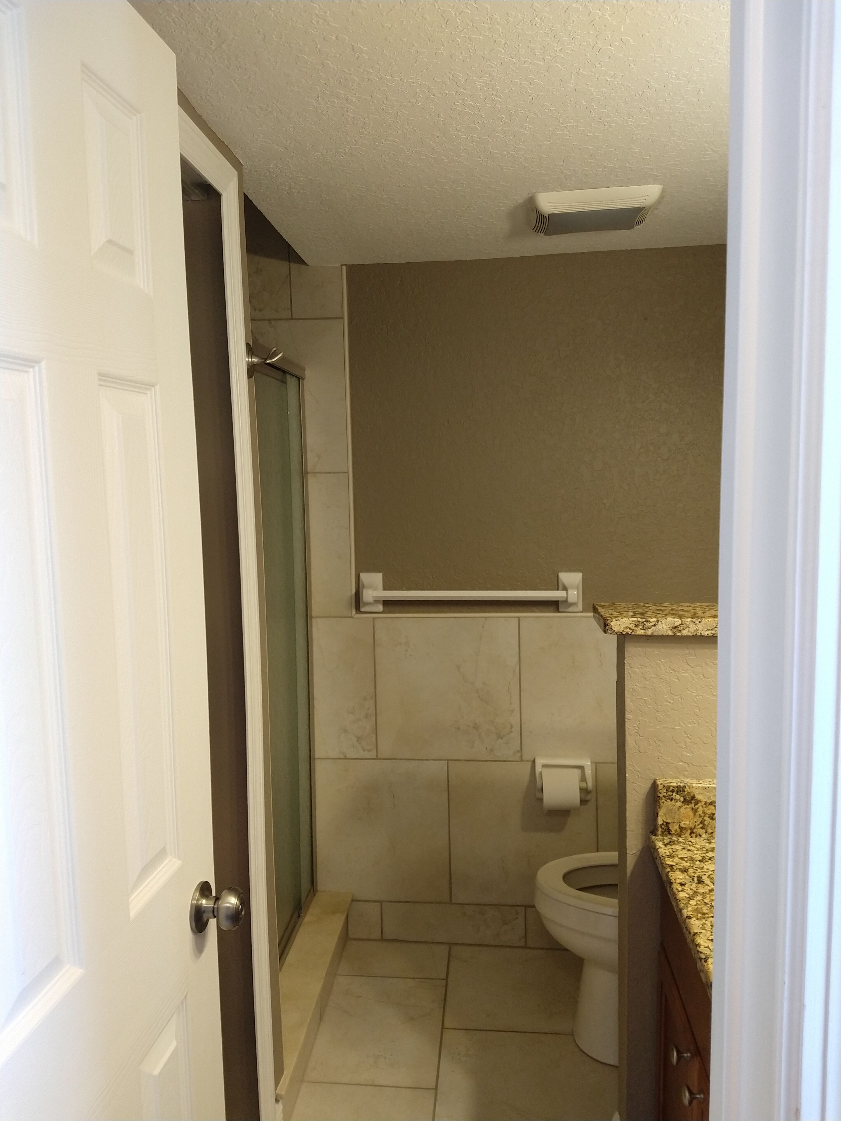 Une petite salle de bain comprenant des toilettes, un porte-serviettes et un espace douche.