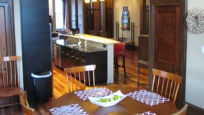 A dining area with a wooden table, chairs, and a chandelier. - Modern meets Historic, Natural Lighting + High Ceilings, Near Metro (Belleville)