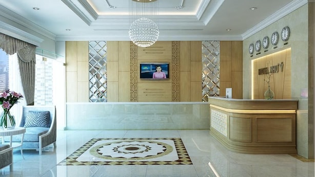 A hotel reception area with a modern chandelier, a TV screen, and a reception desk. - Nhu Y Hotel (Ho Chi Minh City)