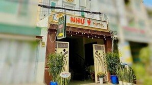 A hotel with a sign reading "NHU HOTEL" and a sign indicating "Con Phong" and "Xinhom". - Nhu Y Hotel (Ho Chi Minh City)