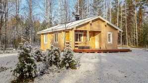 A log cabin with a front porch, surrounded by a snowy forest. - Kesäniitty by Interhome (Ähtäri)