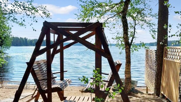 A wooden swing set by a lake with a view of the water. - Kesäniitty by Interhome (Ähtäri)