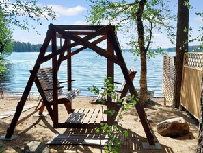 A wooden swing set by a lake with a view of the water. - Kesäniitty by Interhome (Ähtäri)