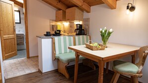 Une cuisine chaleureuse avec des meubles de rangement en bois, une table à manger avec des chaises et un banc.