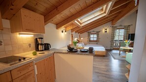 Une cuisine avec des meubles de rangement en bois, un plan de travail et une lucarne.