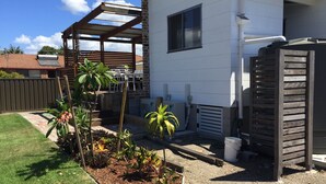 A residential property with a covered patio, outdoor seating, and a garden area with various plants. - Swansea Lakeside Retreat is a large property on the shores of Lake Macquarie (Swansea)