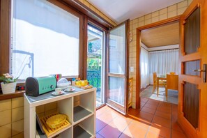 A kitchen with a toaster, a basket, and a window with a view of a balcony. - Chiara's Home, Pregassona (Lugano), Switzerland (Pregassona (Lugano))