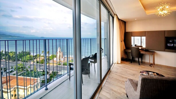 A modern living room with a large balcony, a piano, and a view of the sea. - Holi Panorama Condotel (Nha Trang)