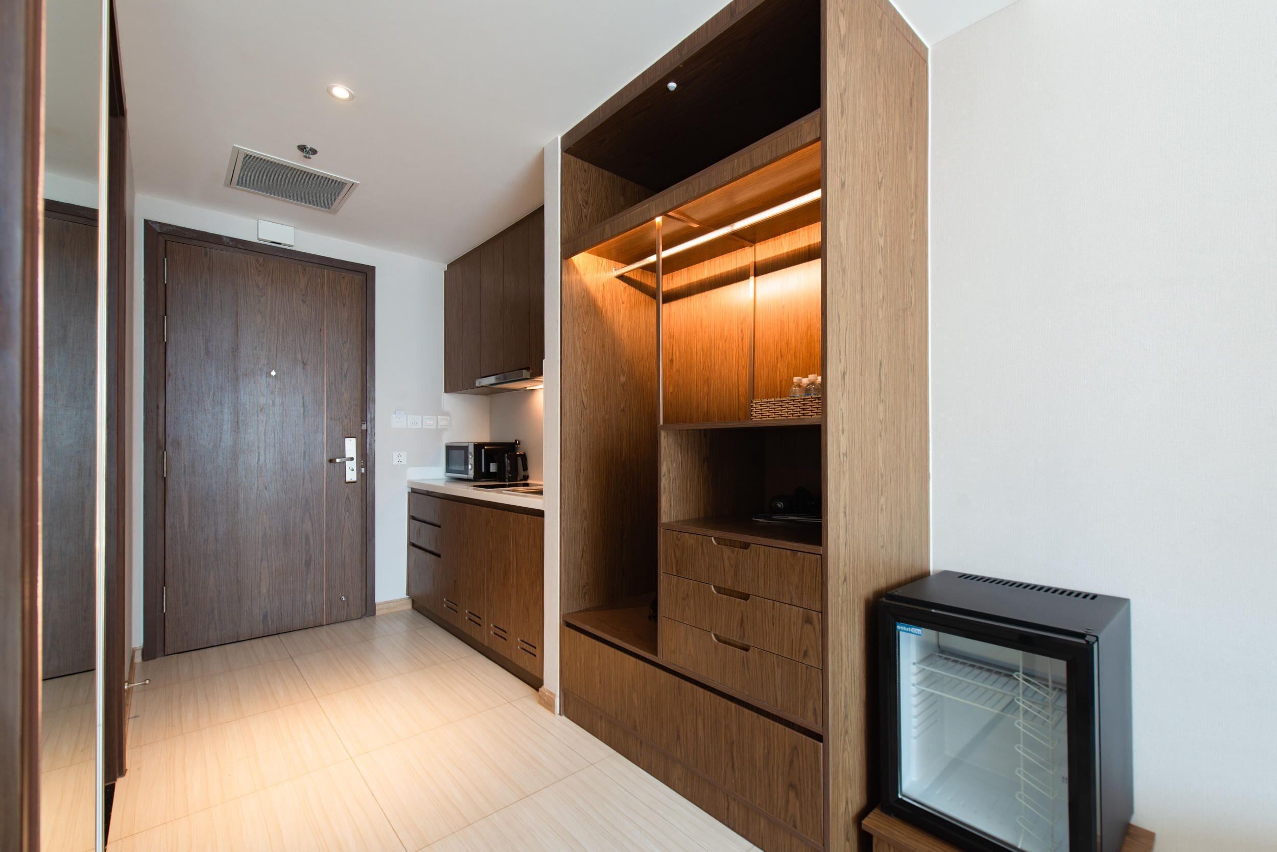 Een moderne keuken met houten kastjes, een magnetron en een inbouwkoelkast.