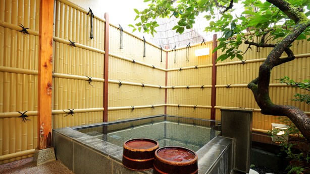 Une pièce de style japonais traditionnel, avec un sol recouvert de tatamis, une petite table en bois et une cloison en verre.