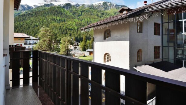 A balcony with a view of a mountain and forest.