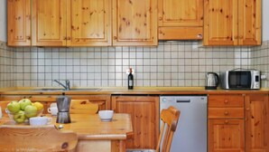 A kitchen with wooden cabinets, a tiled backsplash, a sink, a microwave, and a dishwasher.