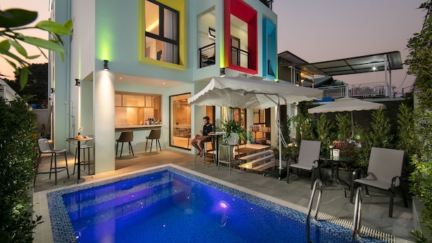 A modern two-story building with a swimming pool, outdoor seating, and a covered patio area. - Viryla Boutique Hotel (Vientiane)