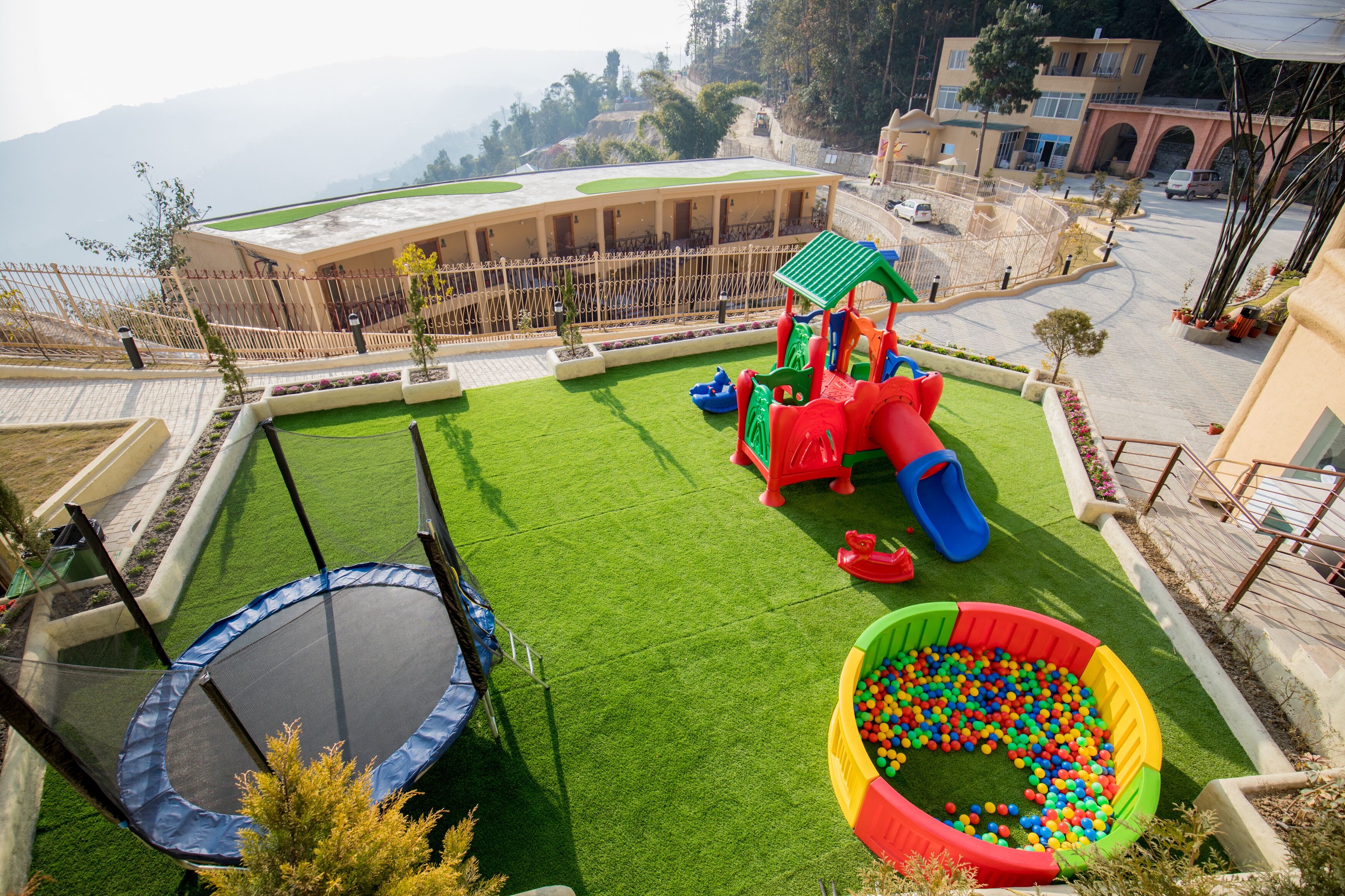 A playground with a slide, a ball pit, and a trampoline.