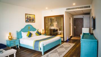 A bedroom with a bed, bedside table, lamp, and a painting on the wall.
