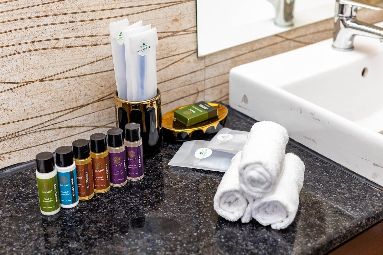 A bathroom counter with toiletries, a towel, and a soap dish.