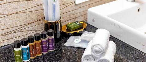 A bathroom counter with toiletries, a towel, and a soap dish.