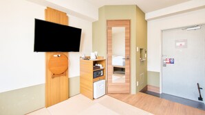 A hotel room with a wooden door, a television mounted on the wall, a small refrigerator, and a microwave. - Rakuten STAY URBAN Shijo Kawaramachi (Kyoto)