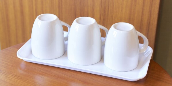 Tres tazas blancas de cerámica sobre una bandeja blanca.