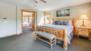 A bedroom with a rustic wooden bed, a bench, a ceiling fan, and a nightstand with a lamp. - Walk to Frisco Marina! Spacious Family Retreat (Frisco)