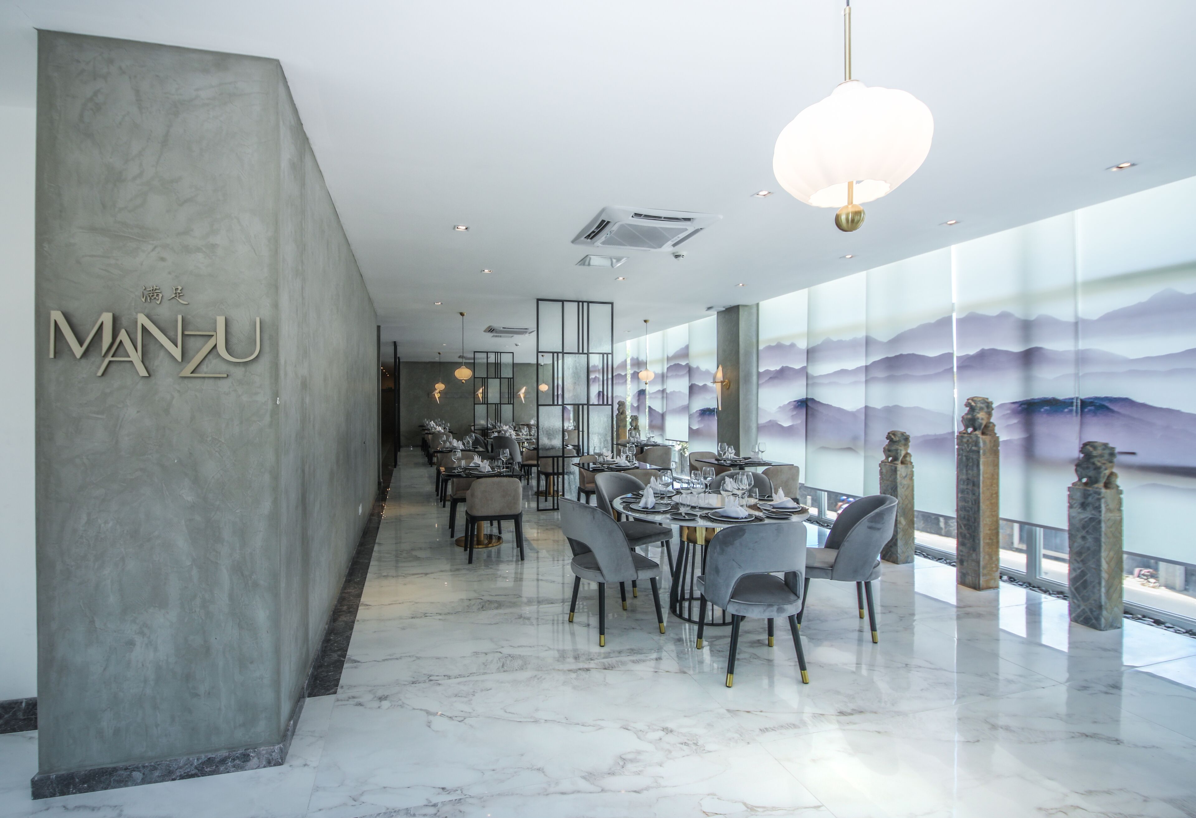 Een modern restaurantinterieur met een lange toonbank, marmeren vloer en een grote muurschildering.