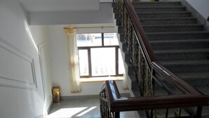 A staircase with a wooden handrail leading to a landing.