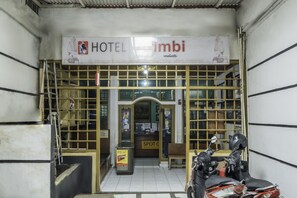 A hotel entrance with a sign reading "HOTEL imbi melati".