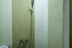 Habitación triple básica | Baño | Ducha, cabezal de ducha tipo lluvia y toallas