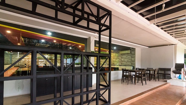 An interior with a dining area, a kitchen, and a bar area. - OYO 2065 Holly Sentosa Hotel (Batam)