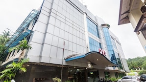 A modern building with a prominent 'OYO' sign, large windows, and a curved entrance. - OYO 2065 Holly Sentosa Hotel (Batam)