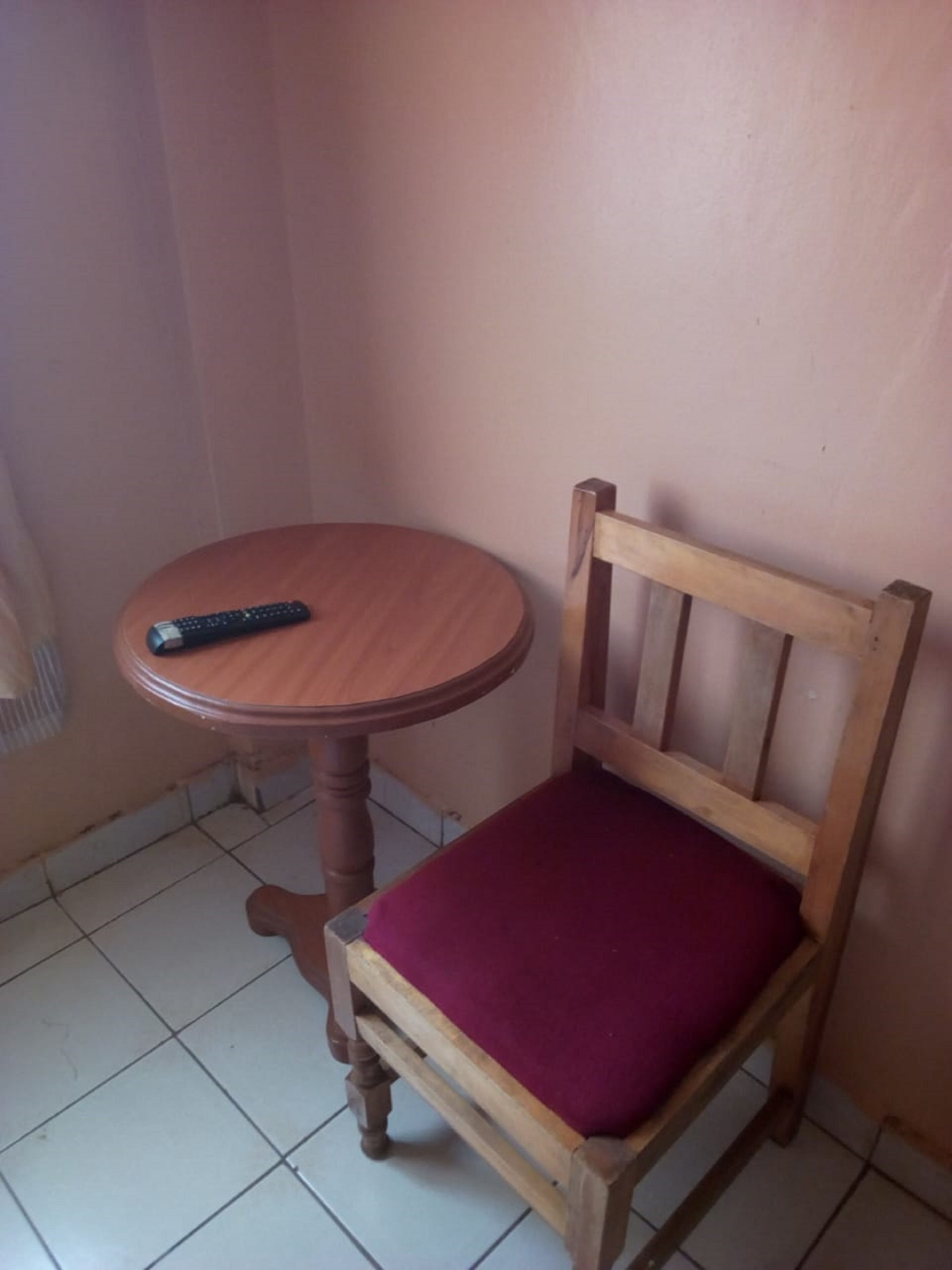 A wooden chair with a cushioned seat and a small wooden table beside it.