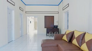 A hotel lobby with a sofa, a desk, and a mirror. - OYO 1190 Griya Soeratin Residence Syariah (Pacitan)