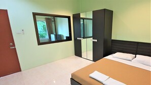 Ein Hotelzimmer mit einem Bett, einem Kleiderschrank, einem Spiegel und einer Tür.