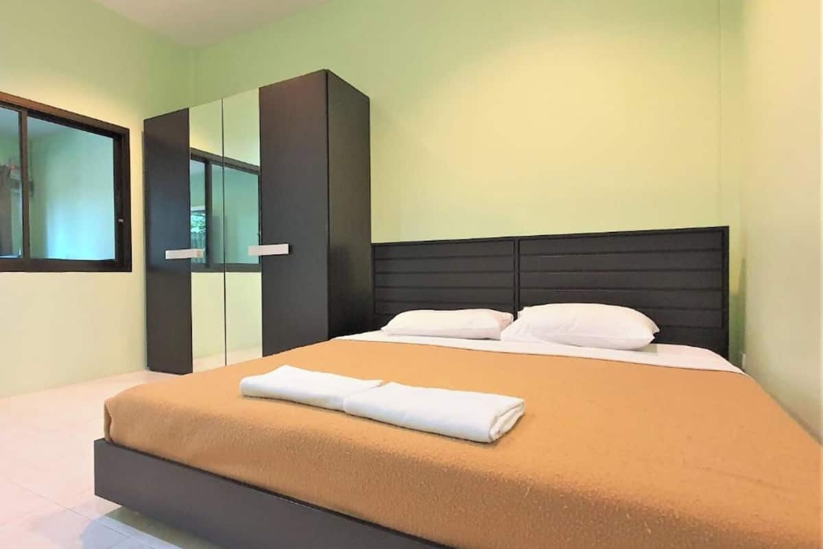 Une chambre à coucher moderne avec un lit, une grande armoire et une fenêtre.
