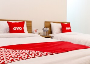 A hotel room with two beds, each with a red pillow labeled "OYO". - Hotel O Monalisa Residence And Cafe (Padang)