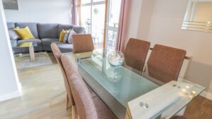 A modern dining area with a glass table, cushioned chairs, and a decorative bowl. - Cumbrae View (Largs)