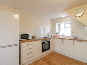Efficient kitchen with oven and microwave, ideal for meal preparation.