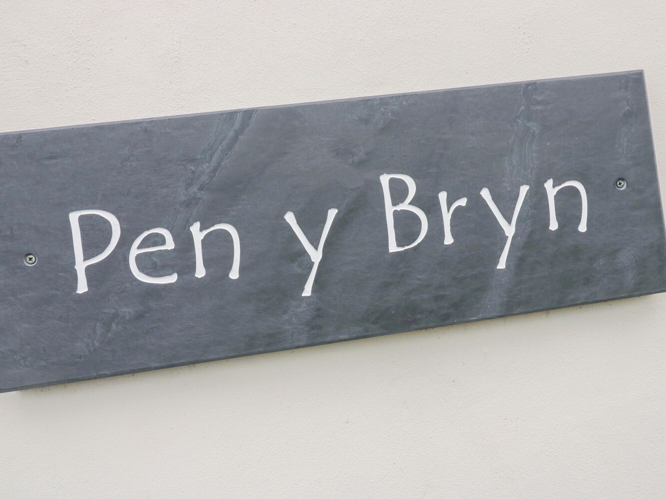 Un senyal de pissarra amb el nom 'Pen y Bryn' escrit.