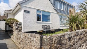 A house with a stone wall, a bench, and a sign reading "2 Bayview". - Bayview (St Austell)
