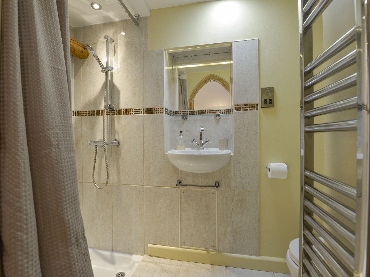 A bathroom with a shower, a sink, and a toilet.
