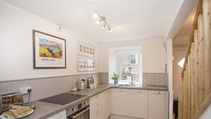 Een moderne keuken met een inbouwoven, een spoelbak en een raam.