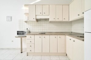 A kitchen with white cabinets, a microwave, and a toaster.