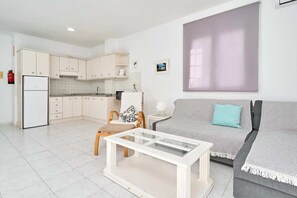 A modern apartment with a kitchen, a dining area, and a living room.