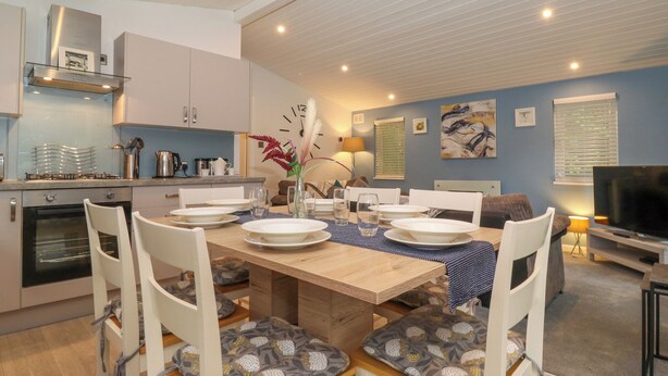 A modern kitchen with white cabinets, a built-in oven, and a stainless steel range hood. - 40 Skiptory Howe (Windermere)