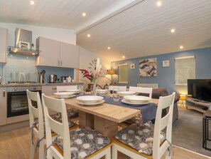A modern kitchen with white cabinets, a built-in oven, and a stainless steel range hood. - 40 Skiptory Howe (Windermere)