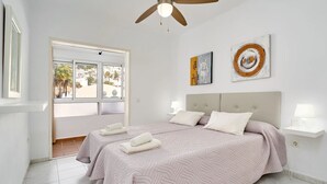 A hotel room with two beds, a ceiling fan, and artwork on the wall. - Suite Nº 9 (2 double rooms) (Nerja)