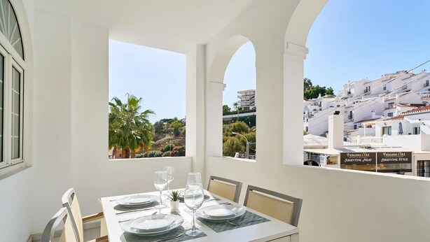 A dining table set with plates, glasses, and cutlery in a room with white walls and large windows. - BB Suite (3 double rooms) (Nerja)