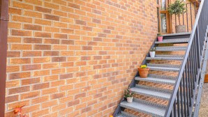 A brick wall with a metal staircase leading to a balcony. - Stonecroft Lodge (Belper)