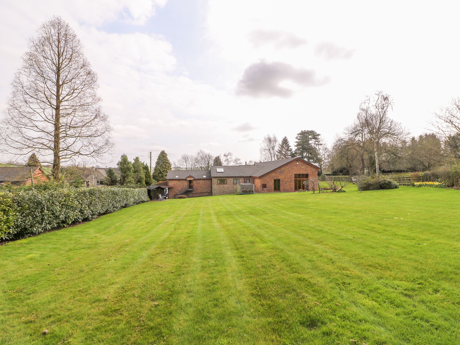 A large, open grassy area with a brick building in the background.